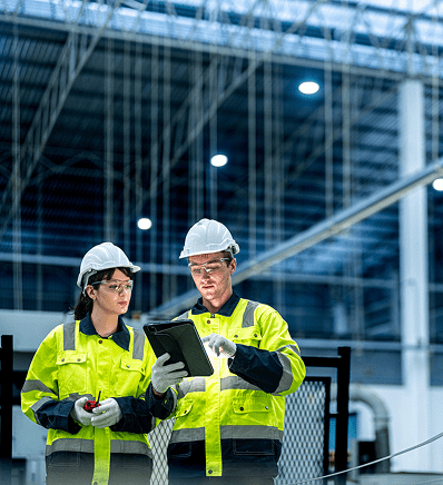 Two people in yellow jackets and hard hats